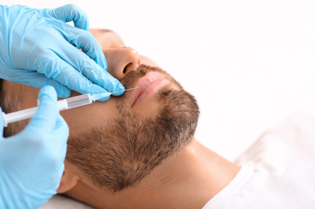 Closeup of man getting lips filler at aesthetic clinic