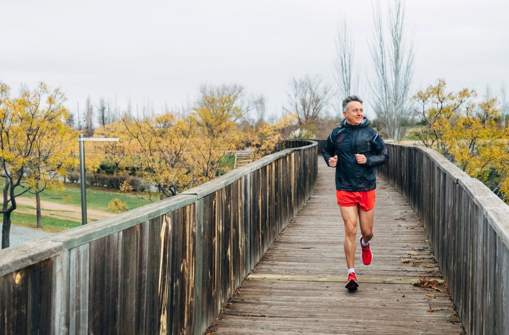 Senior retired man runs and performs exercise
